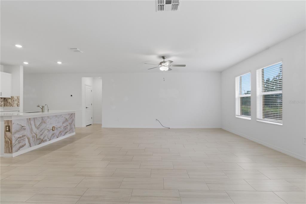 2455 Lanier Road Zephyrhills, FL 33541 - Photo 16 of 39 an empty room with chandelier fan and windows