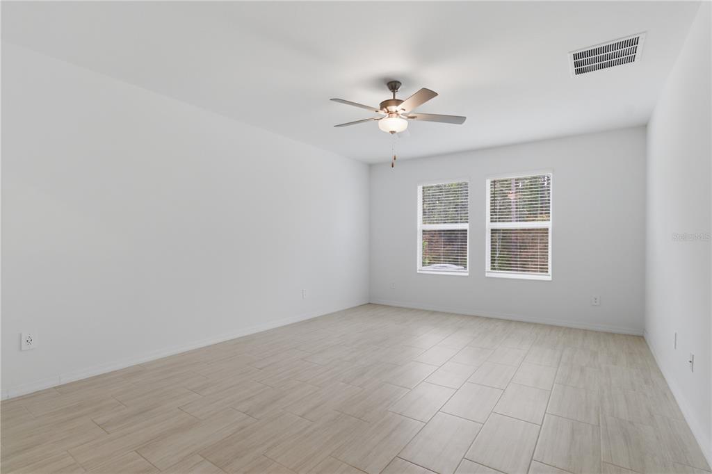2455 Lanier Road Zephyrhills, FL 33541 - Photo 17 of 39 a view of empty room with wooden floor and fan