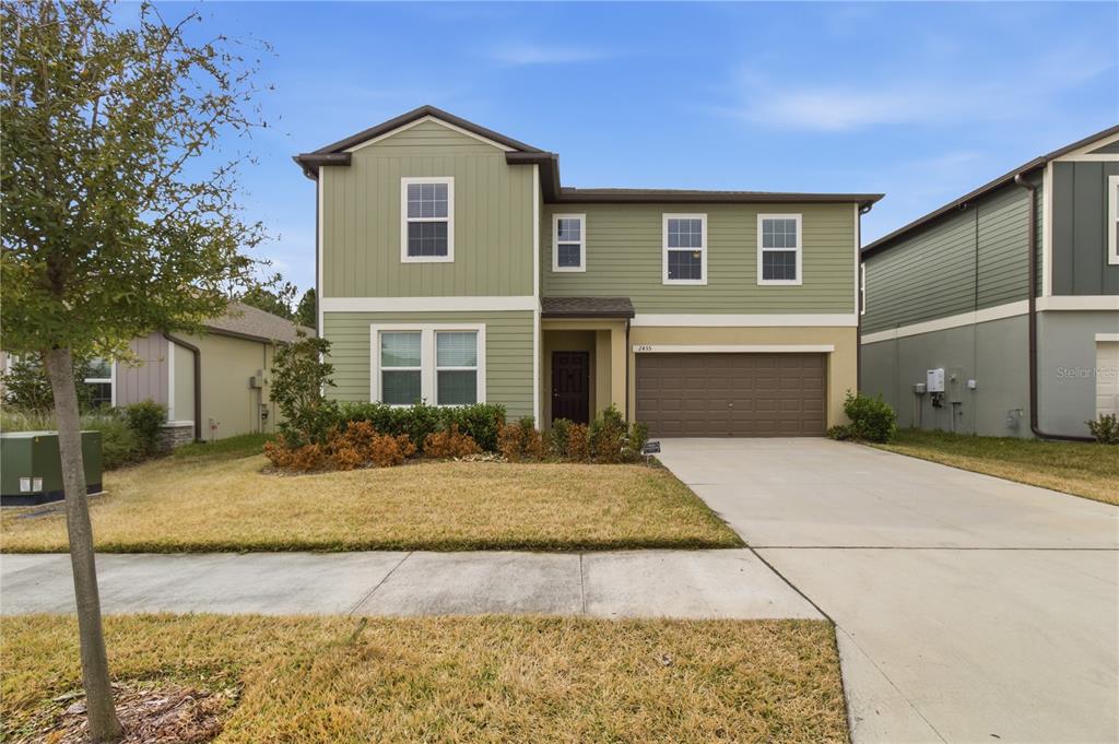 2455 Lanier Road Zephyrhills, FL 33541 - Photo 2 of 39 a front view of a house with garden
