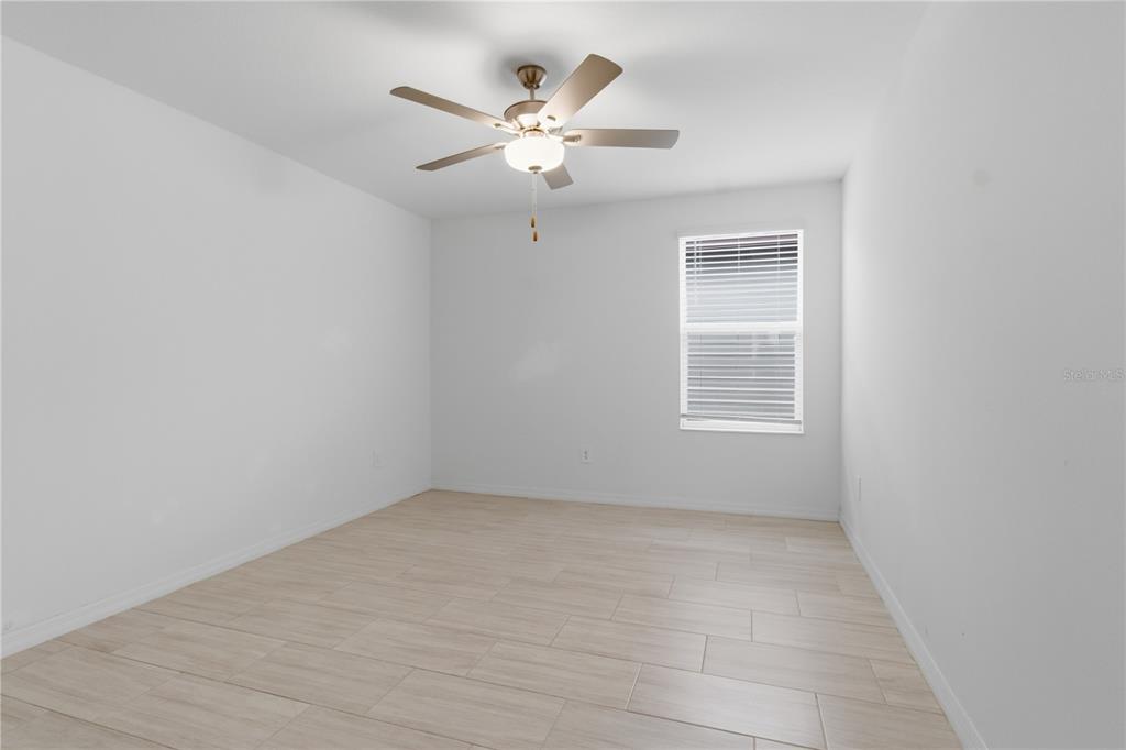 2455 Lanier Road Zephyrhills, FL 33541 - Photo 32 of 39 an empty room with chandelier fan and windows