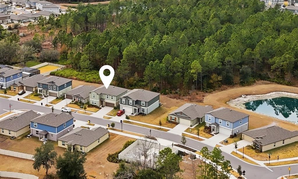 2455 Lanier Road Zephyrhills, FL 33541 - Photo 37 of 39 an aerial view of residential house with parking space and trees