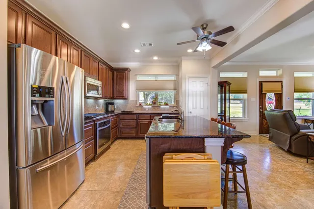 a kitchen with stainless steel appliances granite countertop a refrigerator and a sink