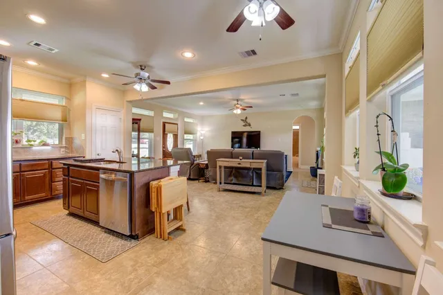 a large white kitchen with lots of counter space a sink and appliances