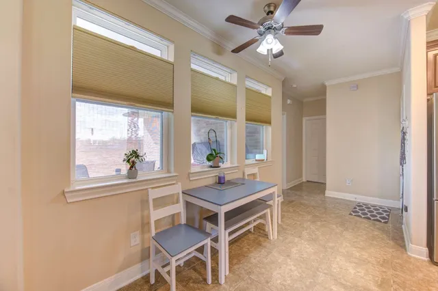 a room with chandelier fan and windows
