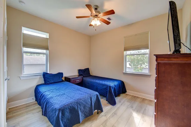a bedroom with two beds and a flat screen tv