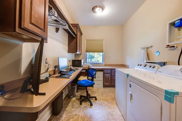 a view of a workspace with furniture and a window