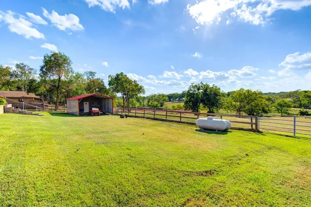 a view of a house with a backyard and a fire pit