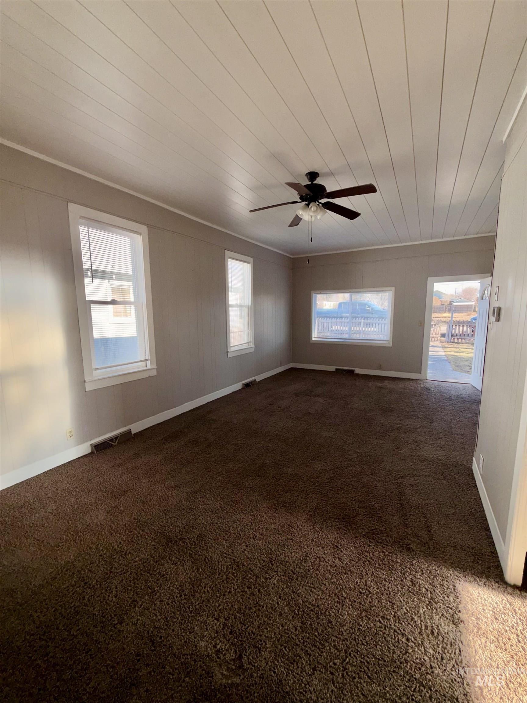 478 2nd Street West Hansen, ID 83334 - Photo 14 of 15 Empty room featuring dark carpet, wooden ceiling, wooden walls, and ceiling fan