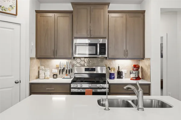 a kitchen with a stove a microwave and a sink
