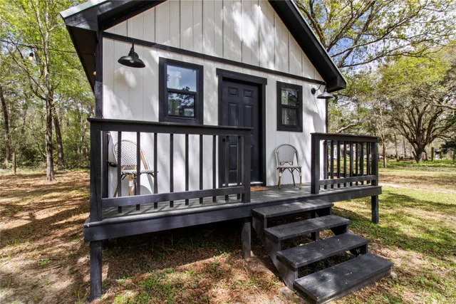 a view of a small house with wooden floor in back
