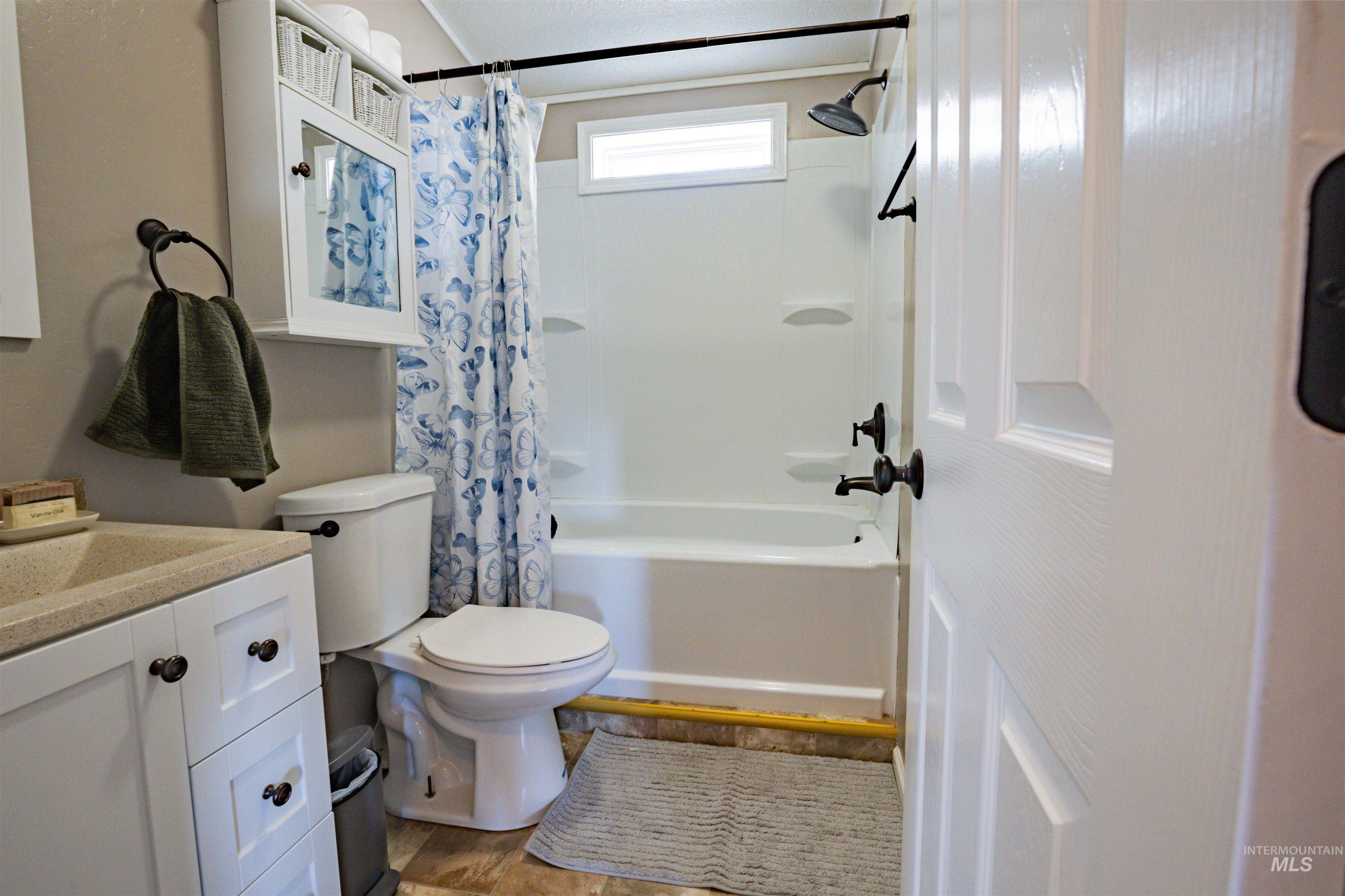 23904 Southview Lane Middleton, ID 83644 - Photo 27 of 29 Bathroom featuring a white vanity with integrated sink, white paneled cabinetry, and dark hardware