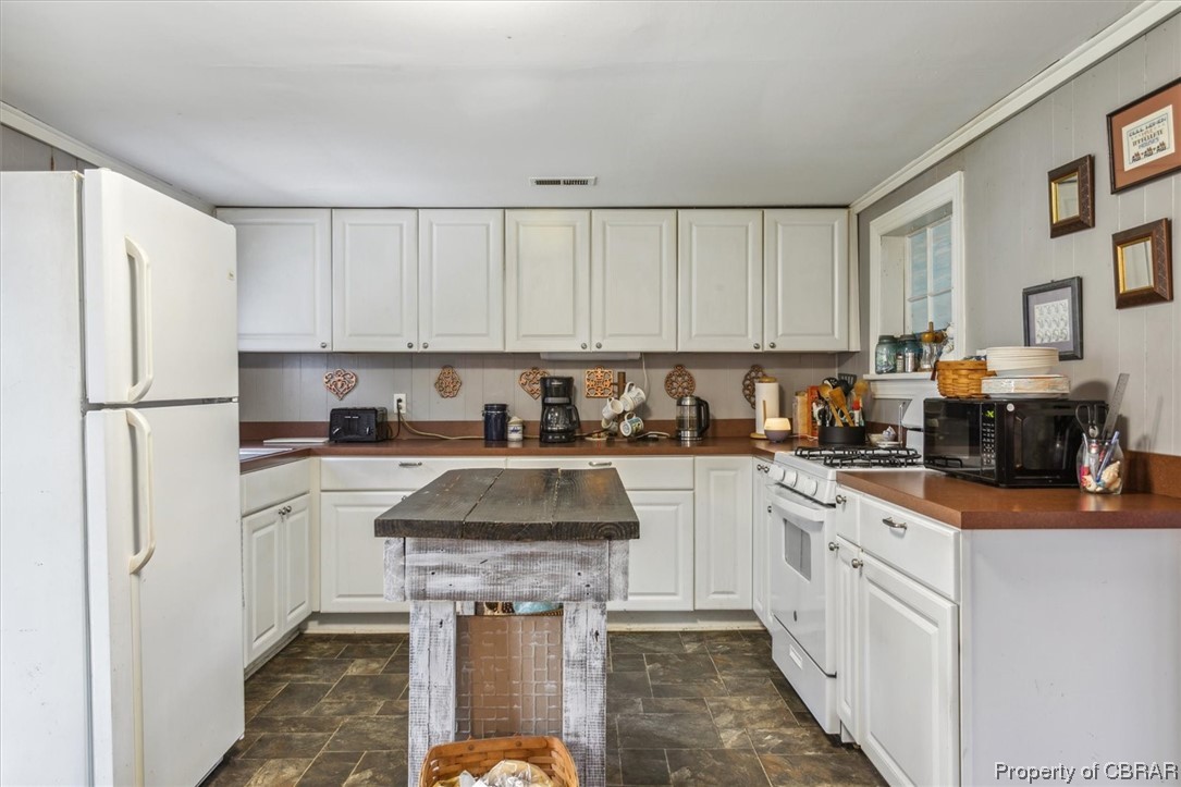 299 Greene Road Mathews, VA 23109 - Photo 15 of 40 a kitchen with granite countertop a refrigerator a stove a sink dishwasher and white cabinets with wooden floor