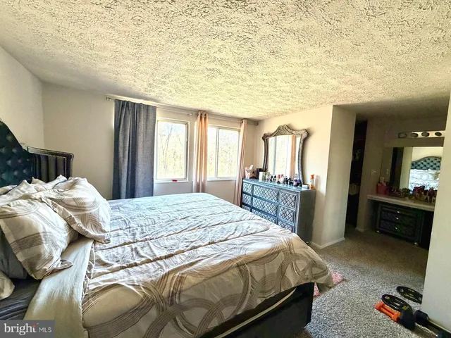 a bedroom with a bed and a large mirror