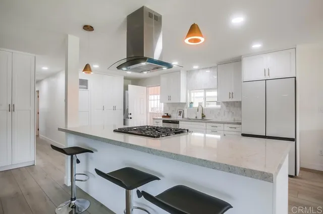a kitchen with stainless steel appliances granite countertop a sink a stove and a refrigerator