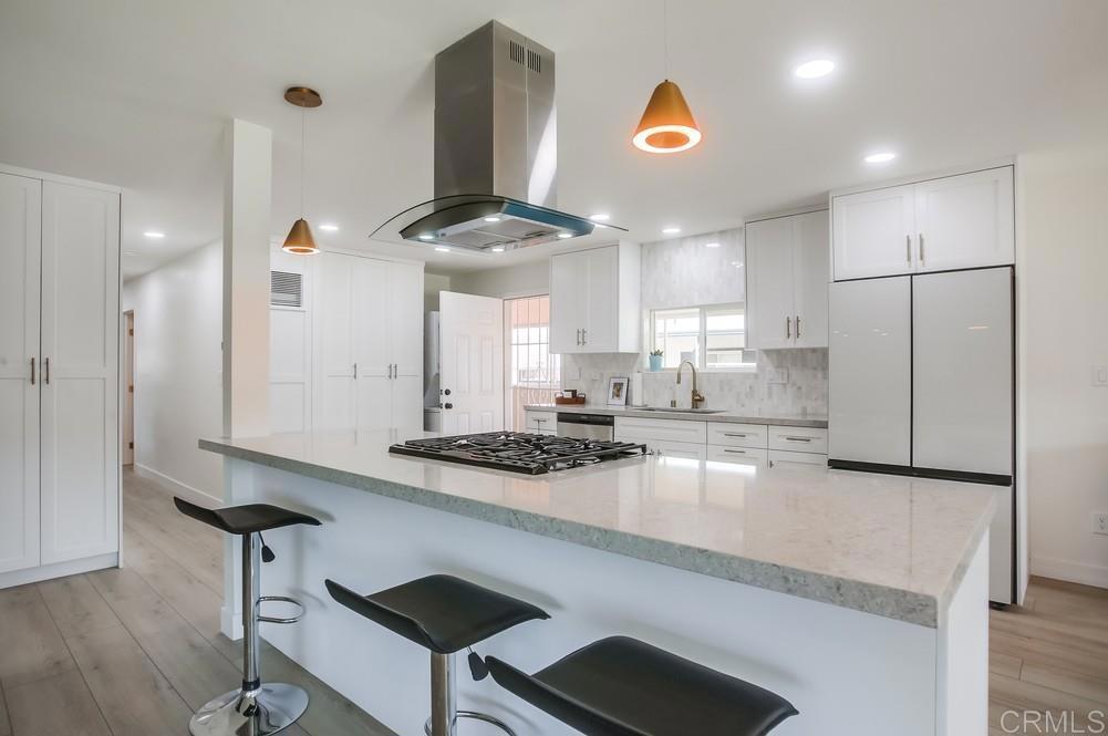 a kitchen with stainless steel appliances granite countertop a sink a stove and a refrigerator