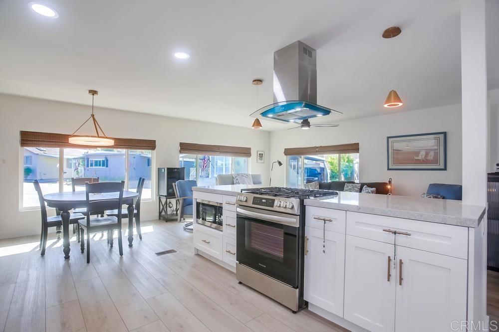8301 Mission Gorge Road Santee, CA 92071 - Photo 12 of 35 a kitchen with a stove a chandelier and chairs
