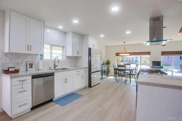 a kitchen with white cabinets and chairs