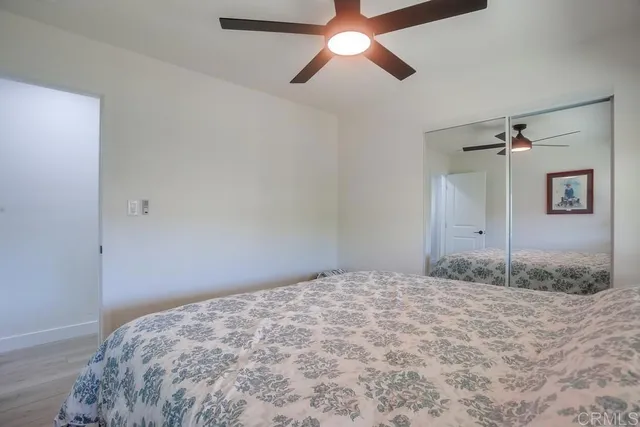 a bedroom with a bed and a chandelier fan