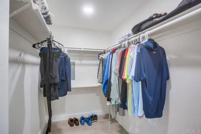a view of walk in closet with clothes and shoes