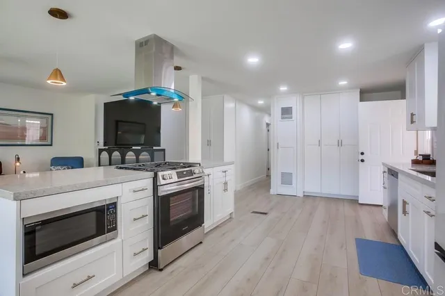 a kitchen with stainless steel appliances a stove a sink and a refrigerator