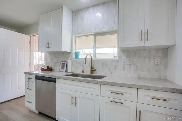 a kitchen with white cabinets and a window