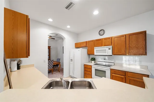 a kitchen that has a lot of cabinets a sink and a stove in it