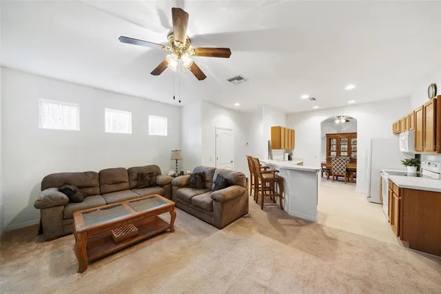 a living room with furniture kitchen view and a chandelier