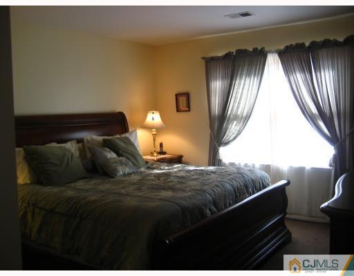 38 Woodbury Road Edison, NJ 08820 - Photo 5 of 10 a bedroom with a bed and wooden floor
