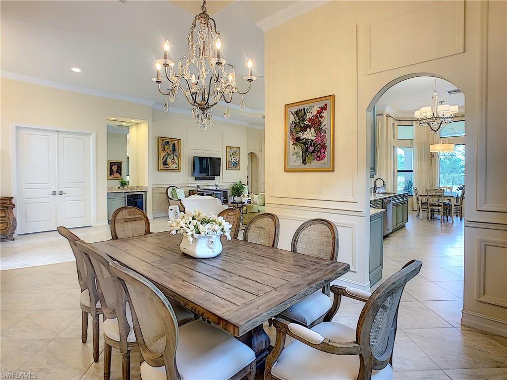 14693 Reserve Lane Naples, FL 34109 - Photo 16 of 34 a dining room with furniture a chandelier and wooden floor