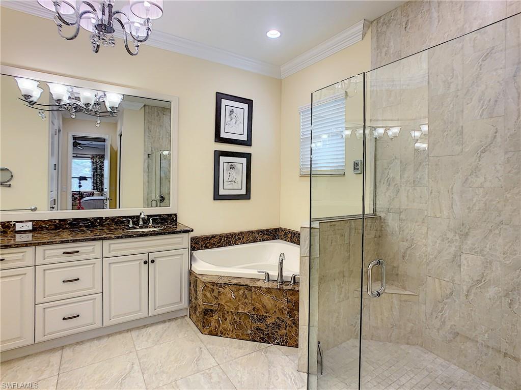 14693 Reserve Lane Naples, FL 34109 - Photo 22 of 34 a bathroom with a granite countertop sink a mirror a bathtub and shower