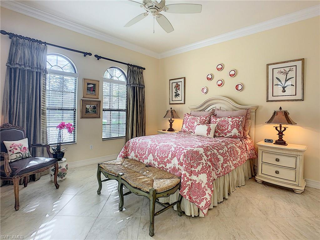 14693 Reserve Lane Naples, FL 34109 - Photo 23 of 34 a bedroom with a bed and a chandelier