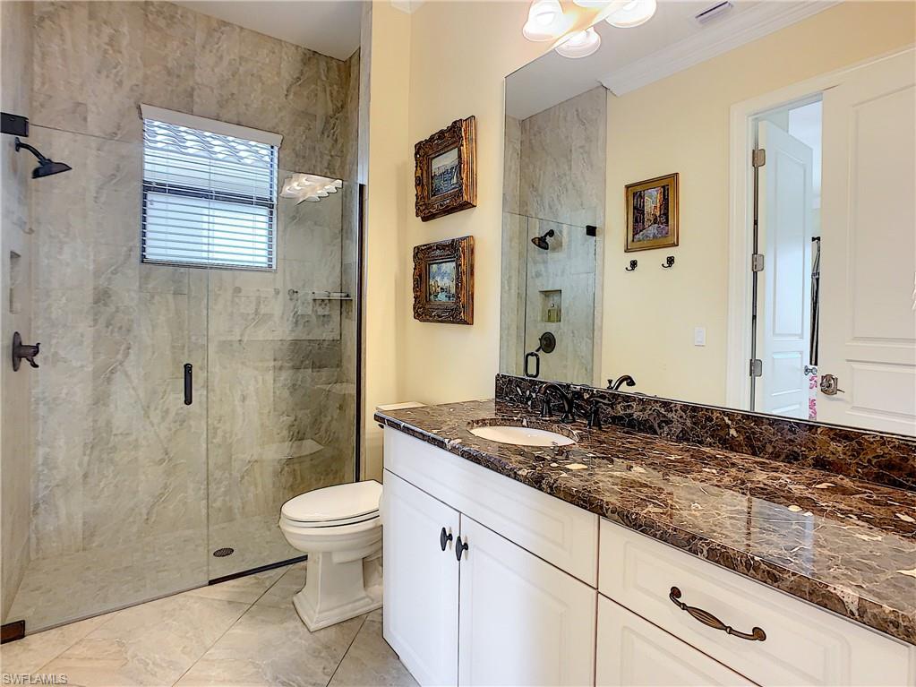14693 Reserve Lane Naples, FL 34109 - Photo 25 of 34 a bathroom with a granite countertop sink toilet and shower