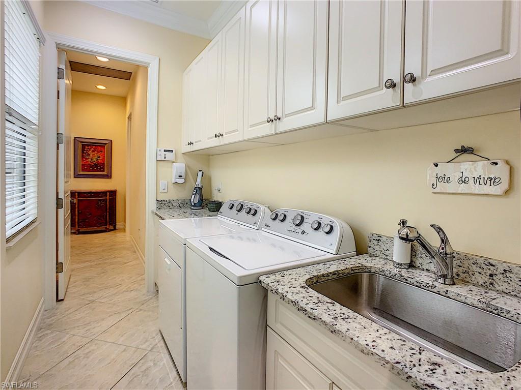 14693 Reserve Lane Naples, FL 34109 - Photo 28 of 34 a kitchen with a sink a stove and a refrigerator