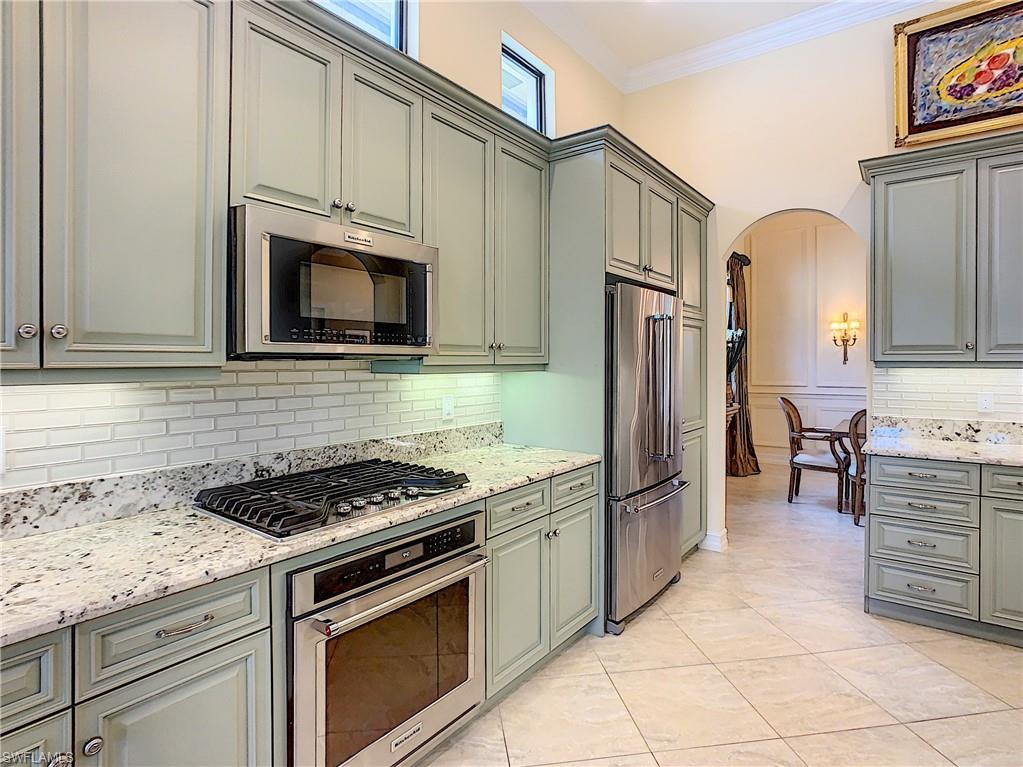 14693 Reserve Lane Naples, FL 34109 - Photo 10 of 34 a kitchen with granite countertop cabinets and steel stainless steel appliances