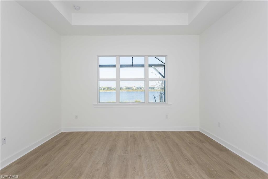 9004 Calypso Court Naples, FL 34113 - Photo 15 of 44 an empty room with wooden floor and windows
