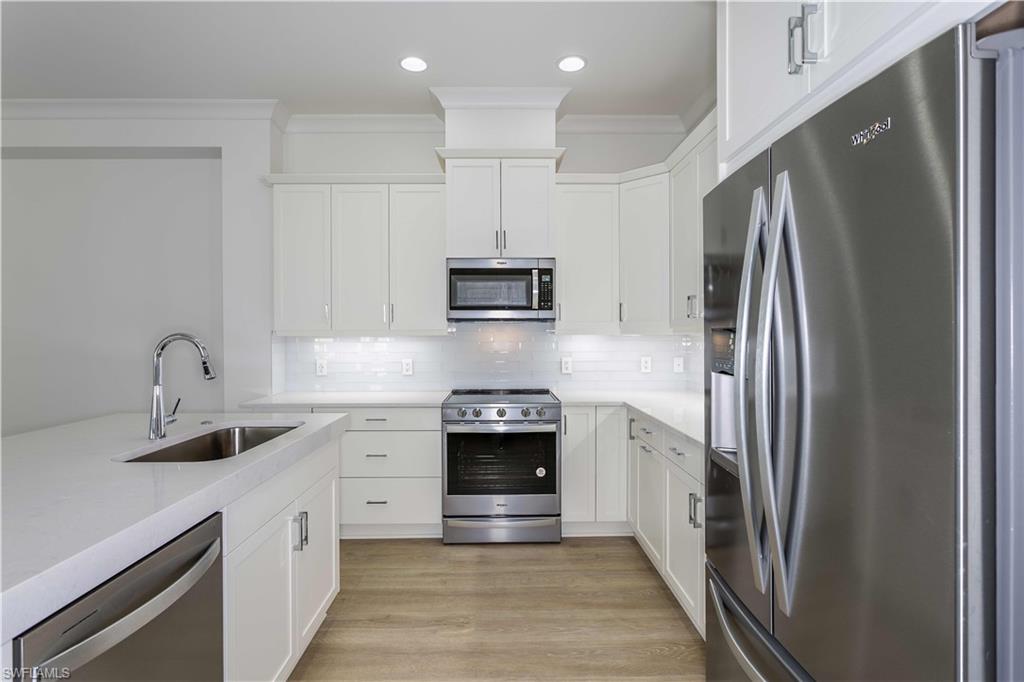 9004 Calypso Court Naples, FL 34113 - Photo 6 of 44 a kitchen with stainless steel appliances granite countertop a refrigerator and a sink