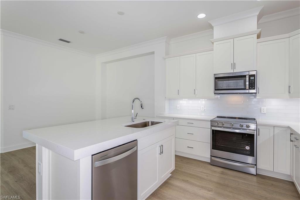 9004 Calypso Court Naples, FL 34113 - Photo 7 of 44 a kitchen with stainless steel appliances granite countertop a stove sink and cabinets