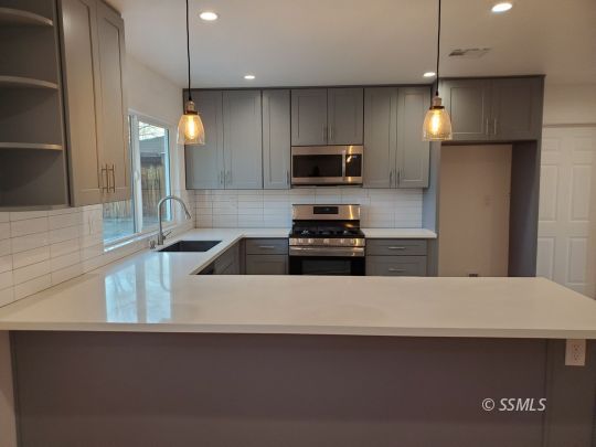 635 West Joyner Avenue Ridgecrest, CA 93555 - Photo 5 of 14 a kitchen with kitchen island a sink stainless steel appliances and cabinets