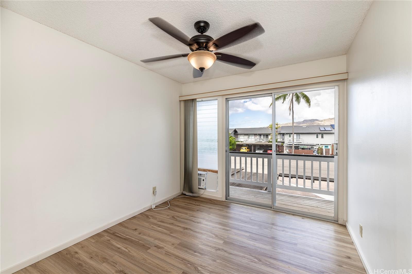 404 Koko Isle Circle, Unit 1802 Honolulu, HI 96825 - Photo 10 of 18 a view of empty room with wooden floor and fan