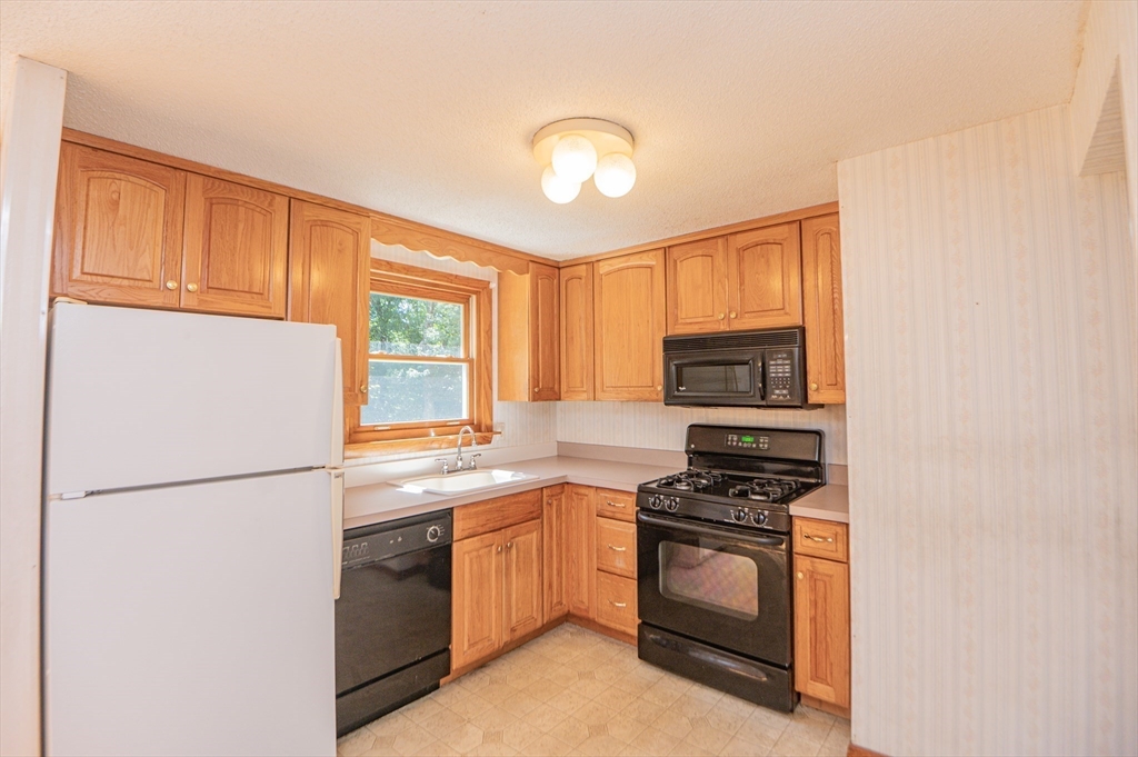 16 Freddy Road Billerica, MA 01821 - Photo 12 of 27 a kitchen with stainless steel appliances granite countertop a refrigerator a stove a sink and a microwave