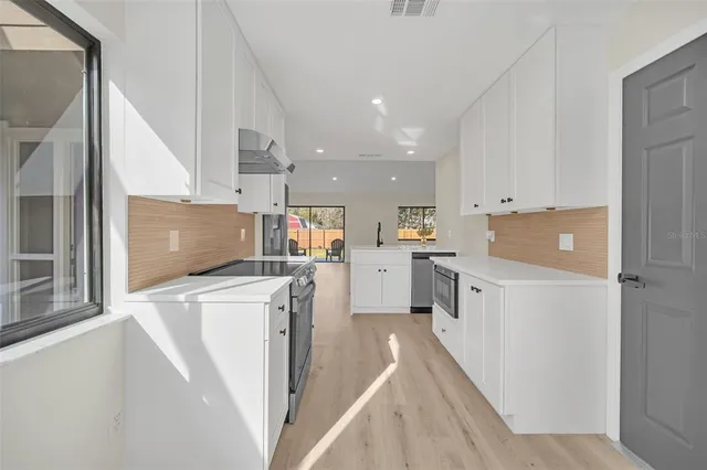 a kitchen with white cabinets and white appliances