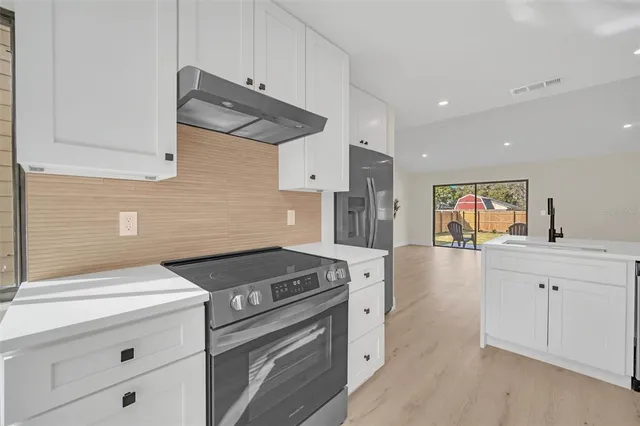 a kitchen with granite countertop a stove and a sink