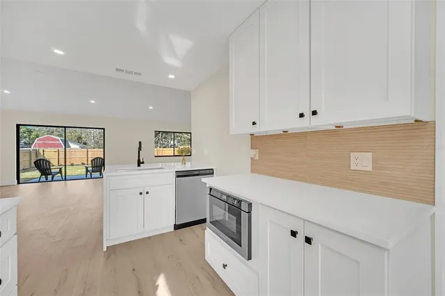 a kitchen with granite countertop white cabinets and white appliances