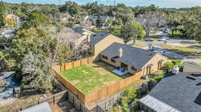 an aerial view of a house with swimming pool and large trees
