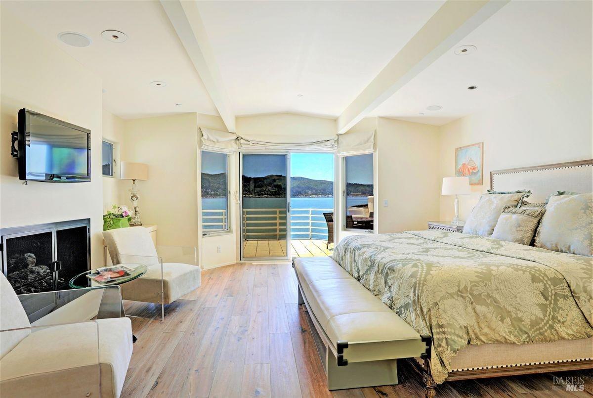 55 West Shore Road Belvedere, CA 94920 - Photo 9 of 16 a spacious bedroom with a bed and a fireplace