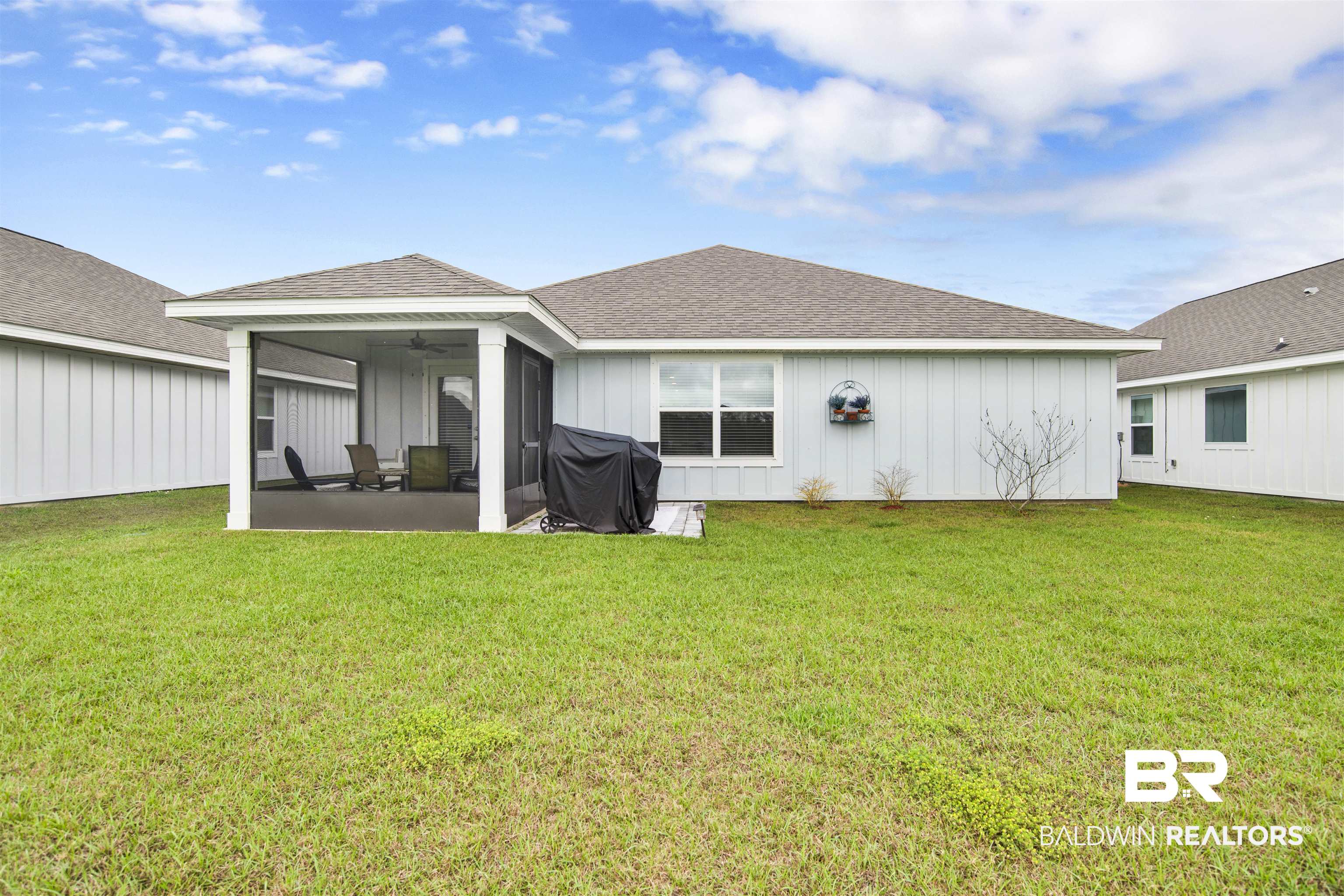 22348 Aleutian Avenue Foley, AL 36535 - Photo 27 of 32 Rear view of property featuring a shingled roof, a lawn, board and batten siding, and a sunroom