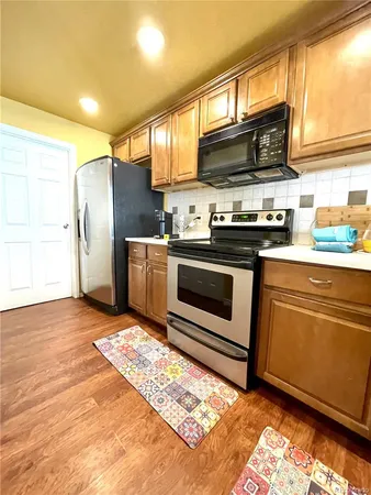 a kitchen with stainless steel appliances granite countertop a stove a sink and a microwave