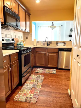 a kitchen with stainless steel appliances granite countertop a stove a sink and a microwave