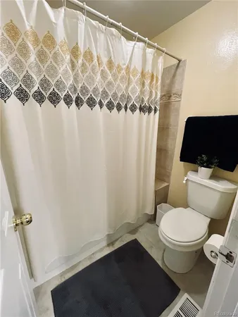 a white toilet sitting next to a shower curtain