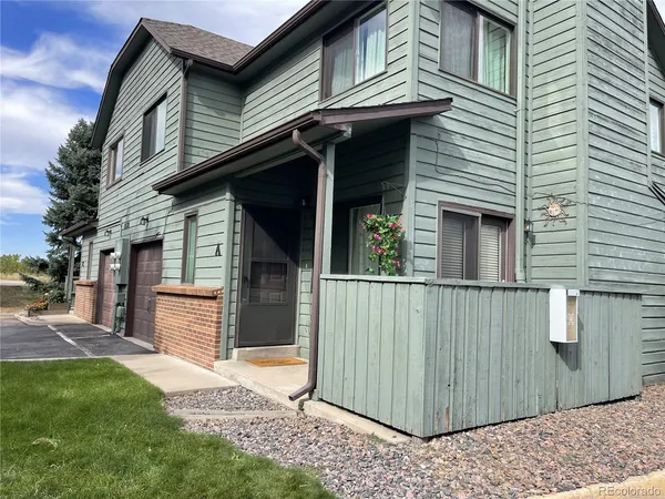a view of a house with a garage and yard